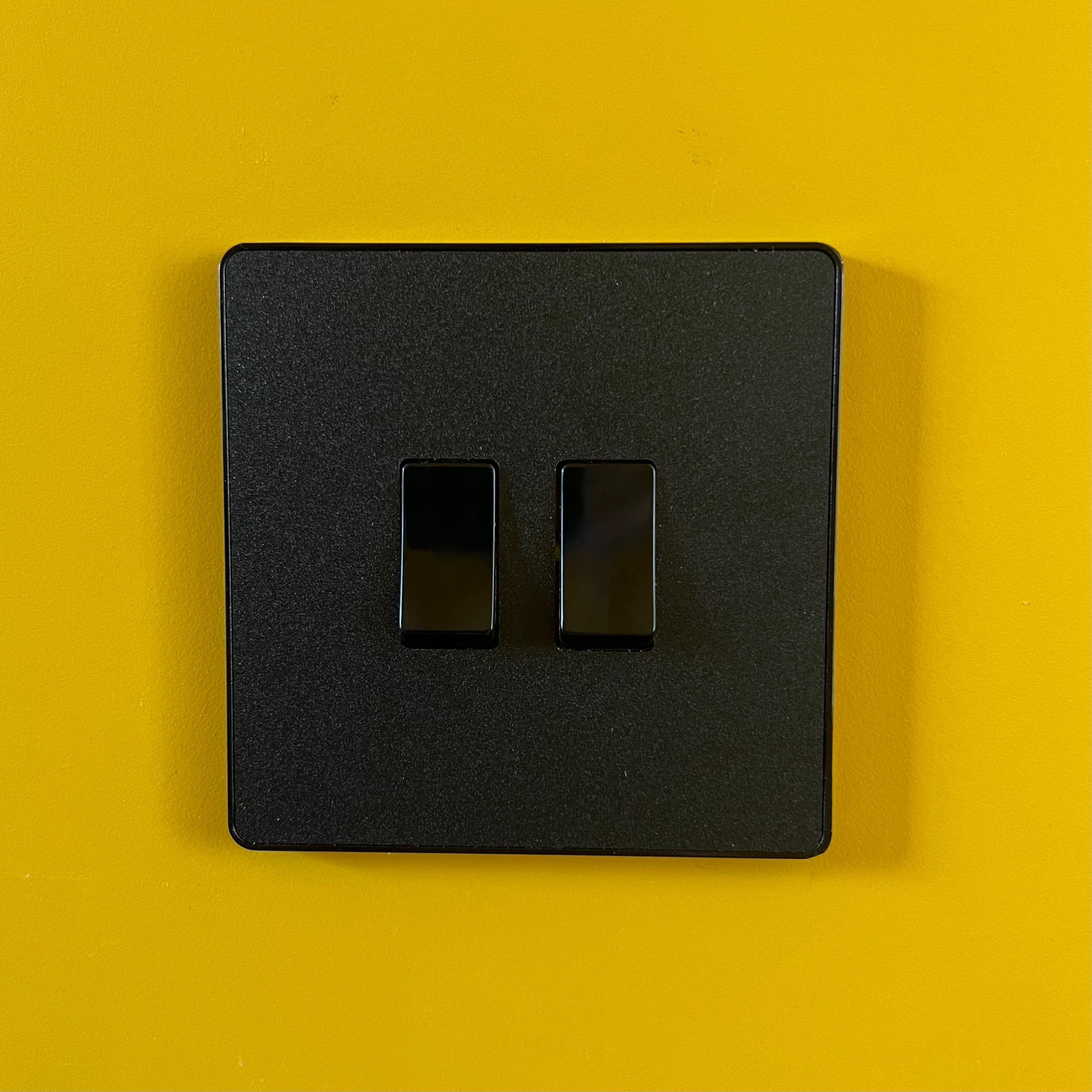 Black switch on yellow wall detail